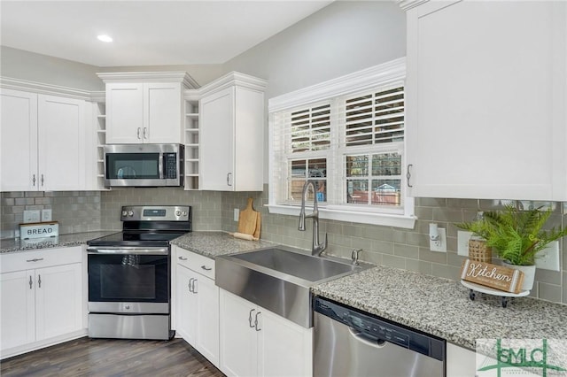 kitchen featuring sink, dark hardwood / wood-style flooring, decorative backsplash, white cabinets, and appliances with stainless steel finishes