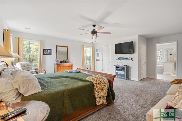 carpeted bedroom with ceiling fan and ensuite bath