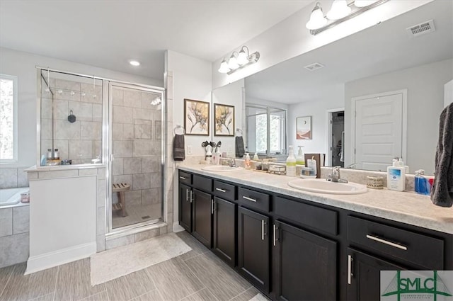 bathroom featuring vanity and independent shower and bath