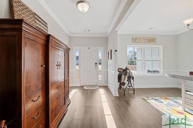 foyer entrance with hardwood / wood-style floors and ornamental molding