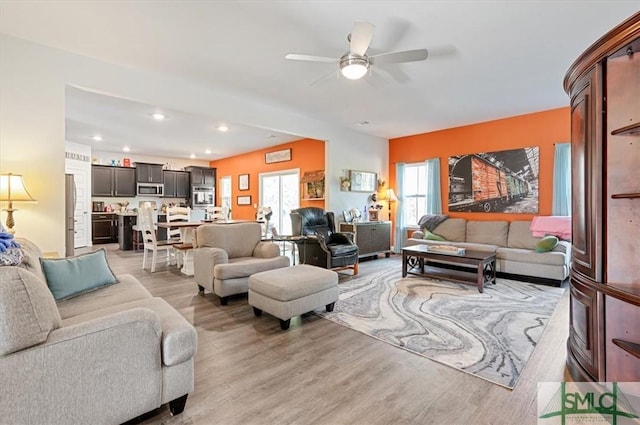 living room featuring light hardwood / wood-style floors and ceiling fan