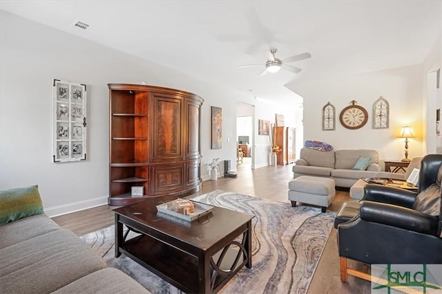 living room with light hardwood / wood-style floors and ceiling fan