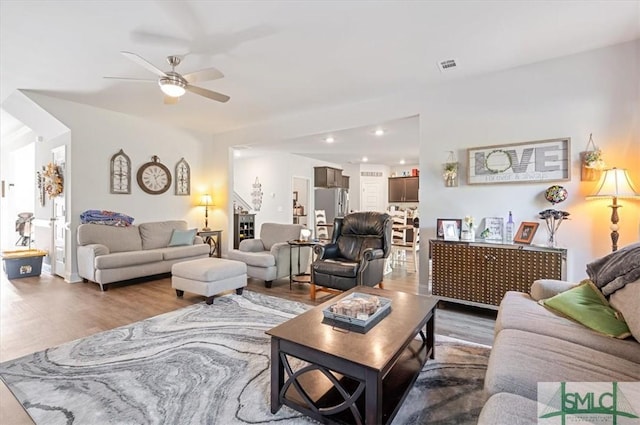 living room featuring hardwood / wood-style floors and ceiling fan