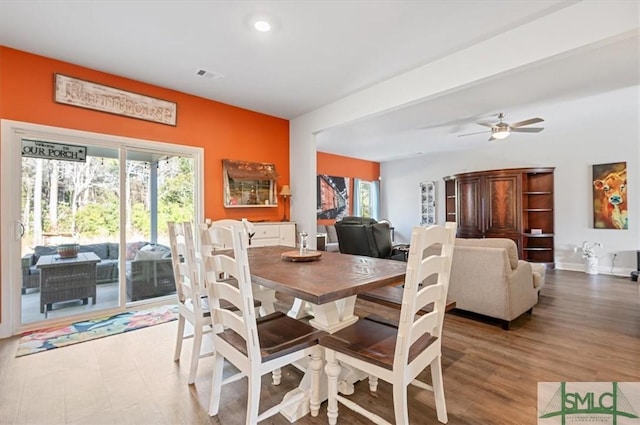 dining area featuring hardwood / wood-style flooring, ceiling fan, and beamed ceiling