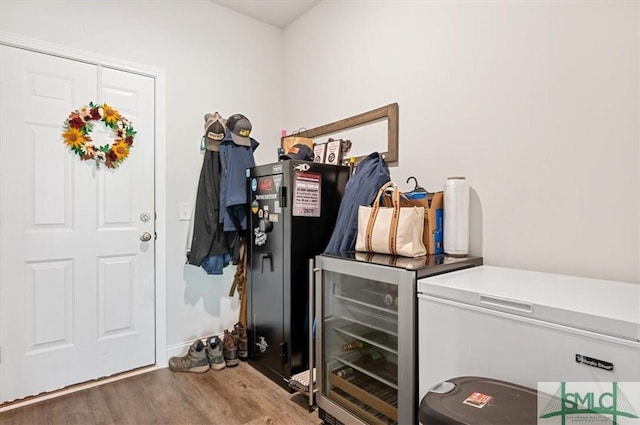 laundry area with hardwood / wood-style floors and bar