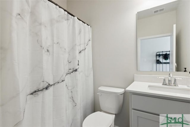 bathroom with vanity, curtained shower, and toilet