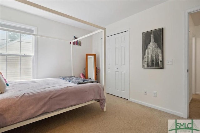 bedroom with light carpet and a closet