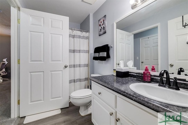 bathroom with toilet, vanity, and hardwood / wood-style flooring