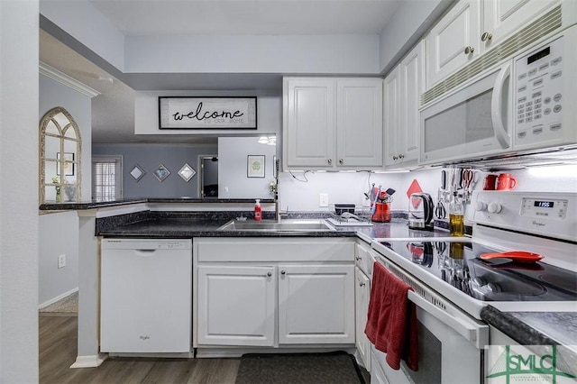 kitchen with sink, white cabinets, dark wood-type flooring, and white appliances