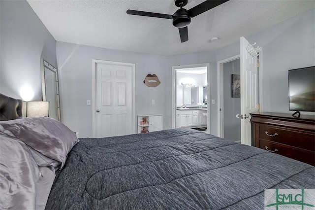 bedroom featuring a textured ceiling, ceiling fan, sink, and ensuite bathroom