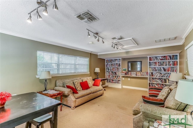 carpeted living room with a textured ceiling, track lighting, and ornamental molding