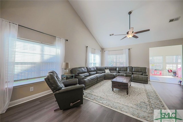 living room featuring dark hardwood / wood-style flooring, ceiling fan, plenty of natural light, and high vaulted ceiling