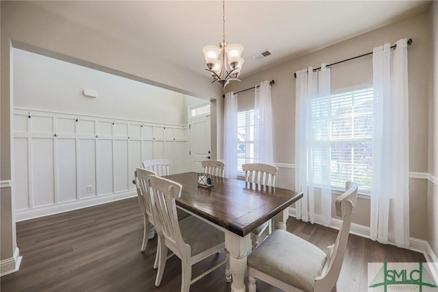 dining area featuring dark hardwood / wood-style floors and a chandelier