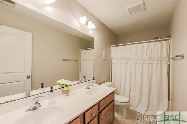 bathroom with toilet, vanity, and tile patterned floors