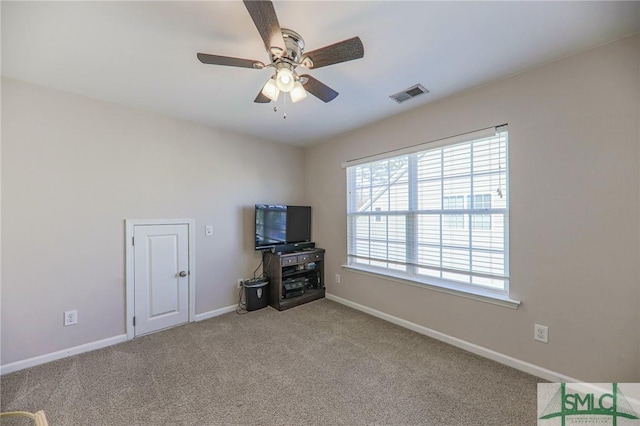 unfurnished living room featuring light carpet and ceiling fan