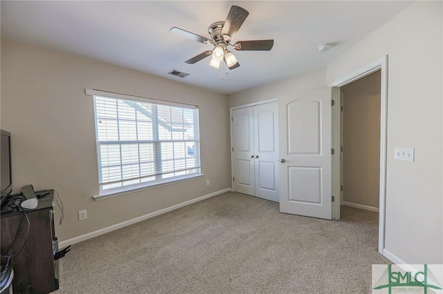 carpeted bedroom featuring ceiling fan and a closet