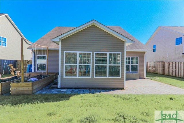 rear view of house with a lawn and a patio