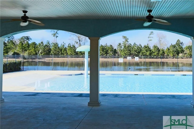 view of swimming pool with a water view and ceiling fan