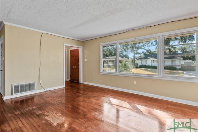 spare room with wood-type flooring, a textured ceiling, and ornamental molding