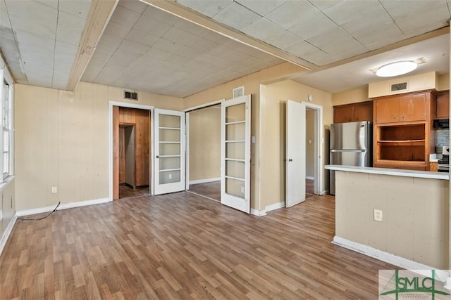 kitchen with stainless steel fridge, light wood-type flooring, and french doors