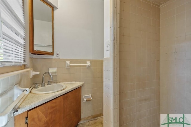 bathroom featuring vanity and tile walls