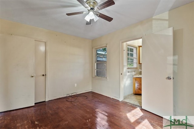 unfurnished bedroom featuring ceiling fan, ensuite bathroom, and hardwood / wood-style flooring