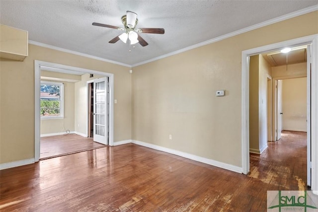 empty room with ceiling fan, crown molding, dark wood-type flooring, and a textured ceiling