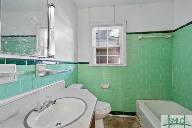 bathroom with a tub, vanity, tile walls, and toilet