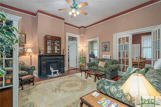 living room featuring hardwood / wood-style flooring, ceiling fan, and crown molding