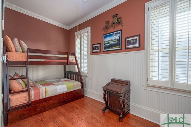 bedroom featuring wood-type flooring and ornamental molding