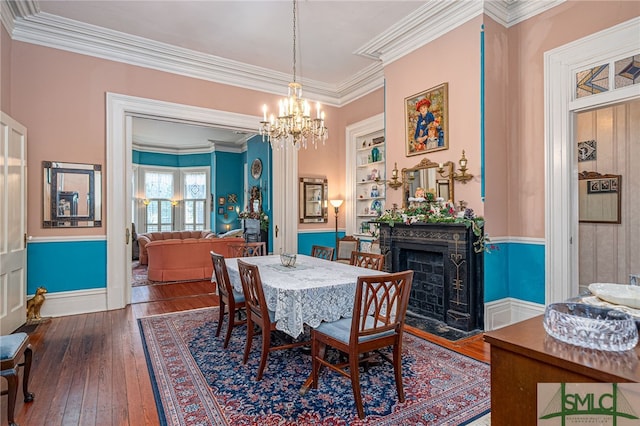 dining room featuring hardwood / wood-style floors, a chandelier, and ornamental molding