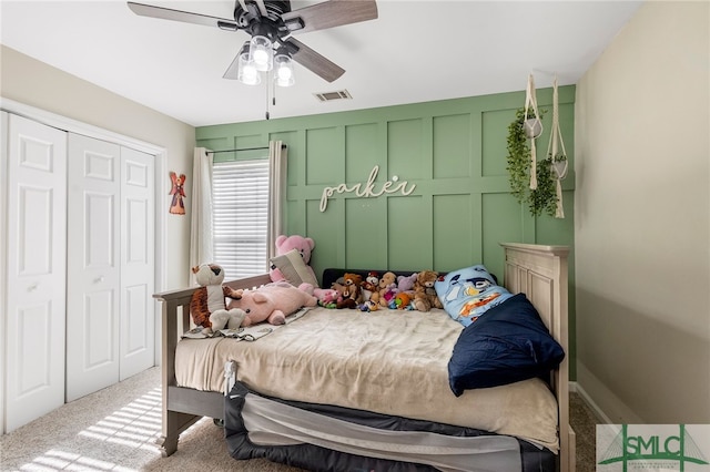 carpeted bedroom featuring ceiling fan and a closet