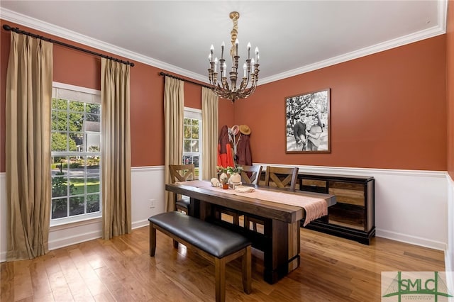 dining area with crown molding, plenty of natural light, a chandelier, and light hardwood / wood-style floors