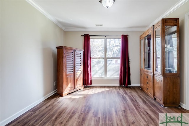 empty room with wood-type flooring and ornamental molding