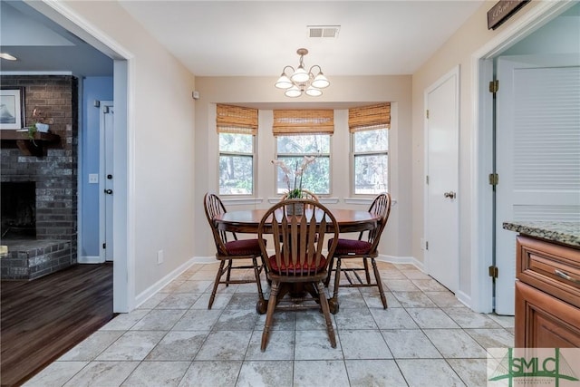 tiled dining room featuring a fireplace and a chandelier