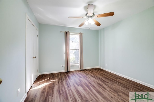 unfurnished room featuring ceiling fan and dark wood-type flooring