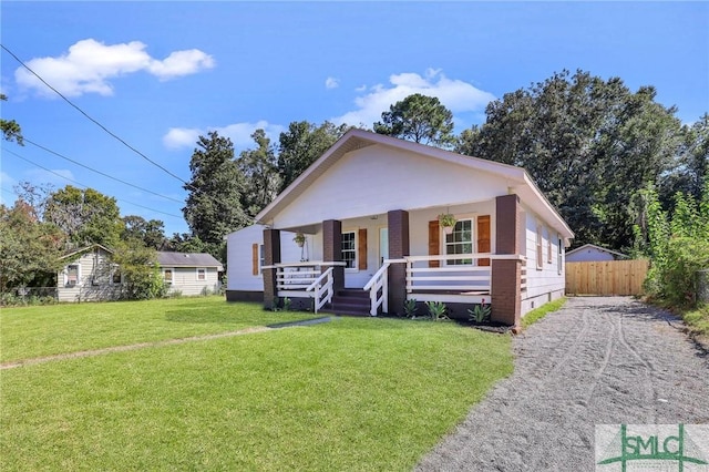 bungalow-style home with covered porch and a front lawn