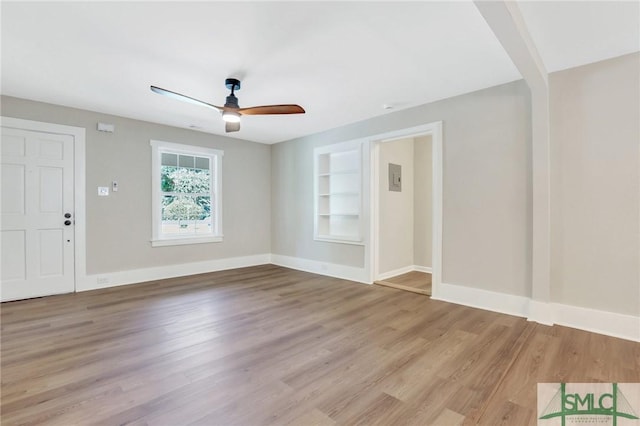 interior space with built in shelves, light hardwood / wood-style floors, and ceiling fan