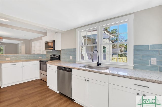 kitchen featuring light stone counters, sink, white cabinetry, and stainless steel appliances