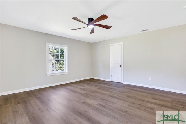 spare room featuring dark hardwood / wood-style floors and ceiling fan