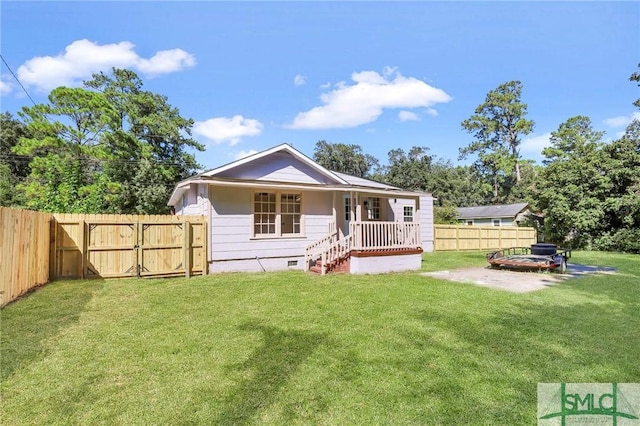 back of property with a lawn and a porch