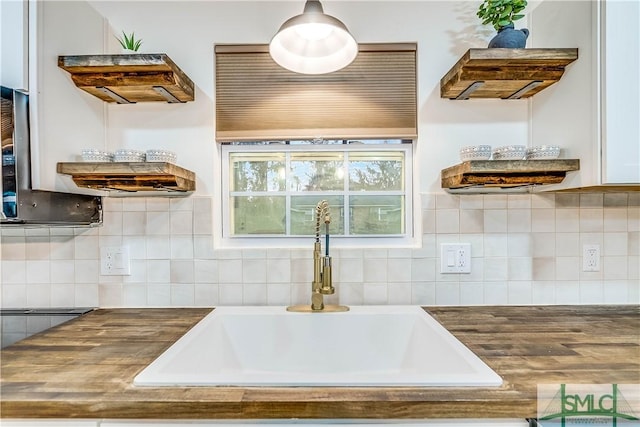 kitchen with backsplash, butcher block counters, and sink