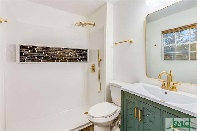 bathroom featuring vanity, toilet, and tiled shower