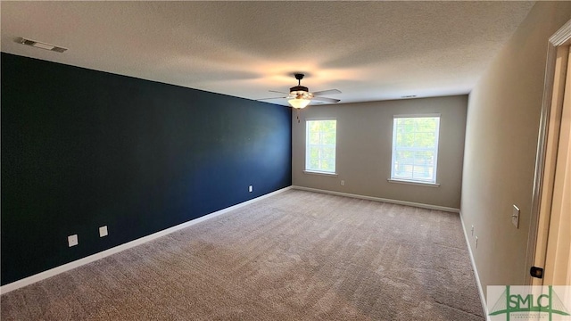 carpeted spare room with ceiling fan and a textured ceiling