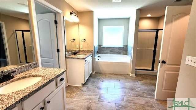 bathroom featuring vanity and independent shower and bath