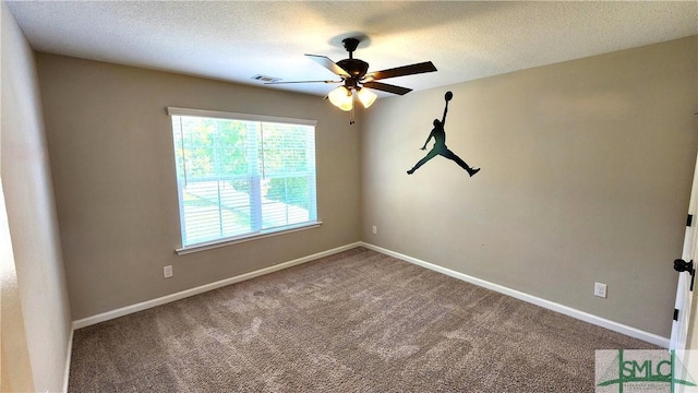 carpeted spare room featuring ceiling fan and a textured ceiling