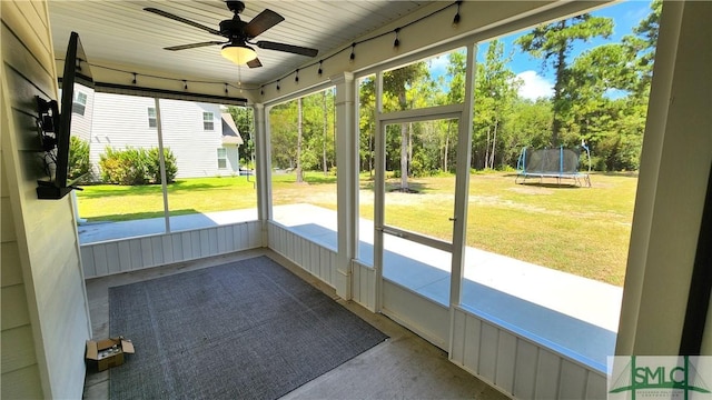 unfurnished sunroom with ceiling fan