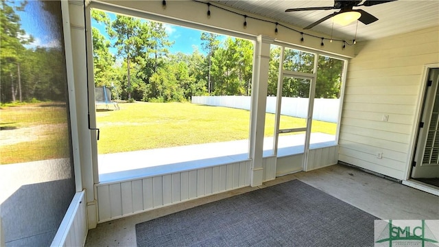 unfurnished sunroom with ceiling fan