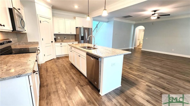 kitchen featuring pendant lighting, decorative backsplash, a center island with sink, white cabinets, and appliances with stainless steel finishes