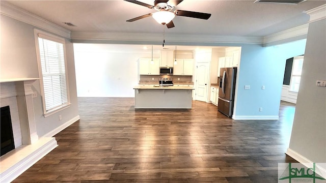 kitchen featuring a kitchen island with sink, white cabinetry, pendant lighting, and stainless steel appliances